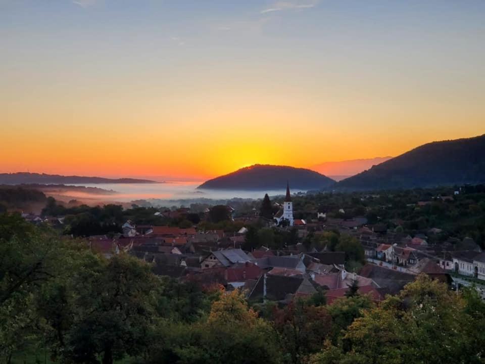 a view of a town with the sunset in the background at Casa ISEHEIA in Sibiel