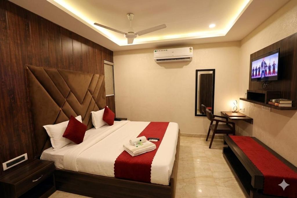 a hotel room with a bed and a television at Hotel Grand In Near 2 Min From Vaishali Metro Station in Ghaziabad