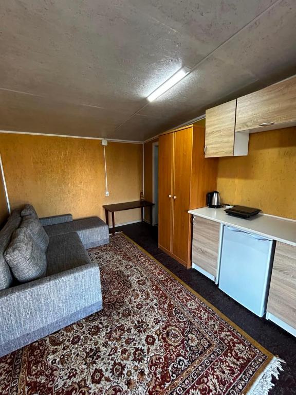a living room with a couch and a kitchen at Номера в Фонтанке in Fontanka