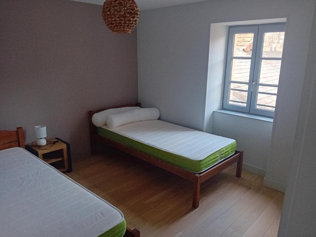 a small room with two beds and a window at ESCALE MORVANDELLE chambre 4 lits 2 salles de bain in Saint-Brisson