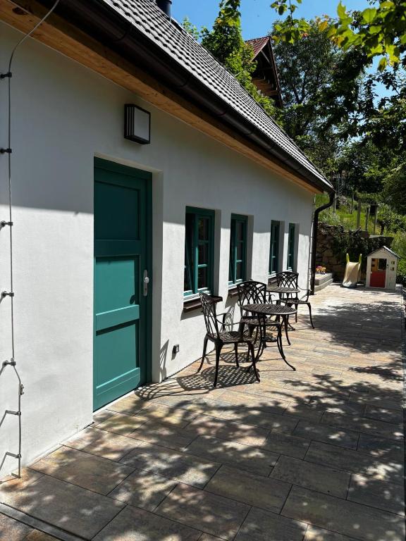 a building with a green door and tables and chairs at Chalupa Renatka in Hartvíkovice