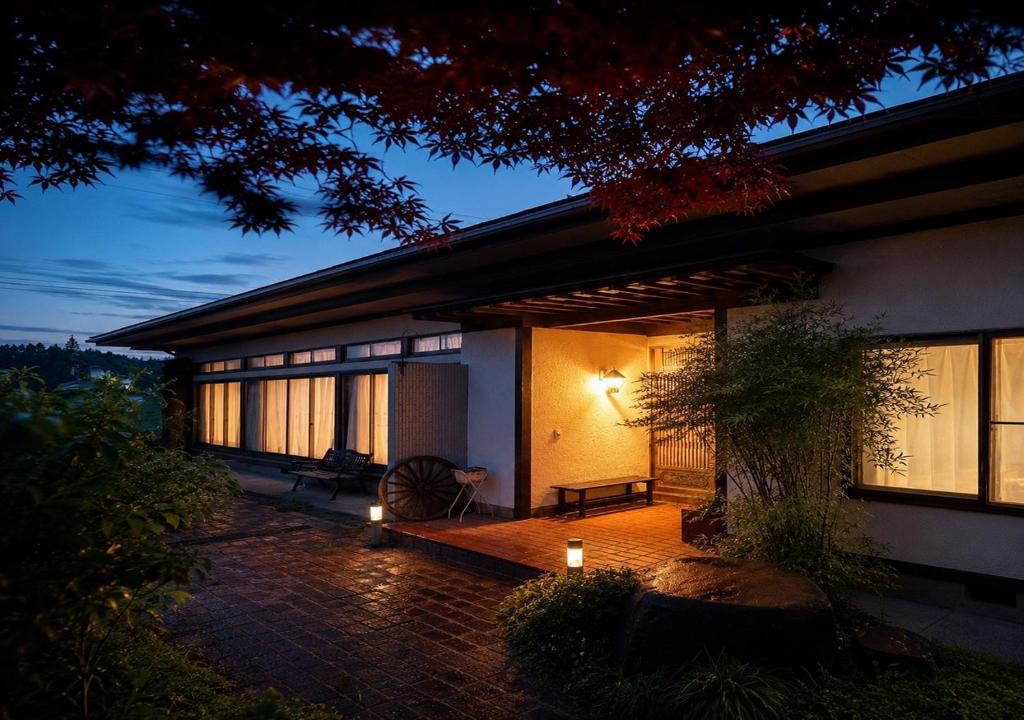 a house with a lit up porch at night at 民泊ごとう in Kitakami