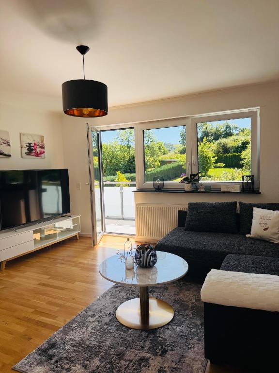 a living room with a couch and a tv and a table at Ferienwohnung Auszeit Langsur in Langsur