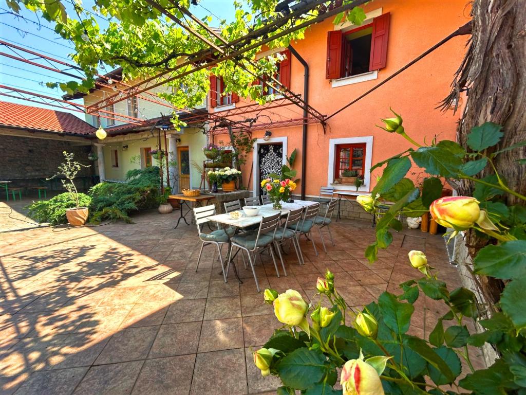 a patio with a table and chairs in front of a house at Domačija Harmonija in Vremski Britof