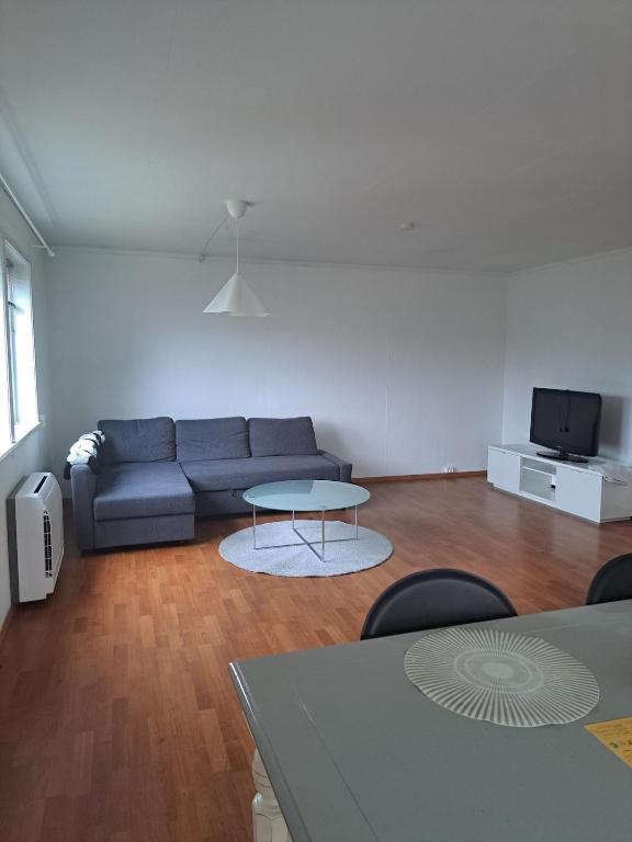 a living room with a couch and a table at Bright and spacious home with good in Klepp