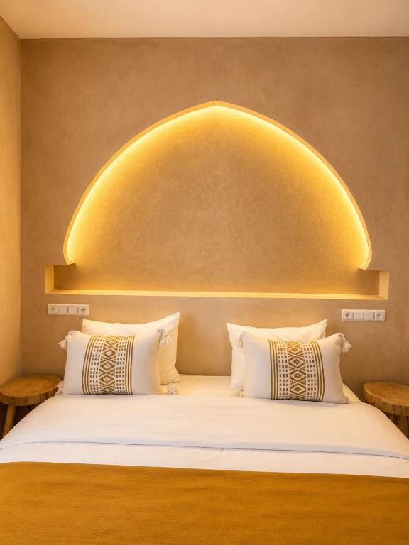 a bed with an arch above it with two pillows at Yara Lodge in Tamraght Ou Fella