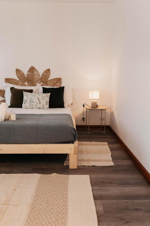 a bedroom with a bed and a table with a lamp at Aurega Vintage Bedrooms by Lethes Legacy in Ponte de Lima
