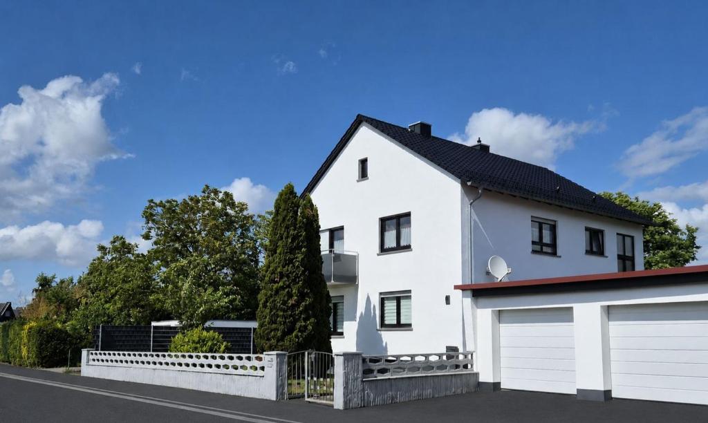 a white house with two garage doors at Ferienwohnung Landwehr in Großostheim