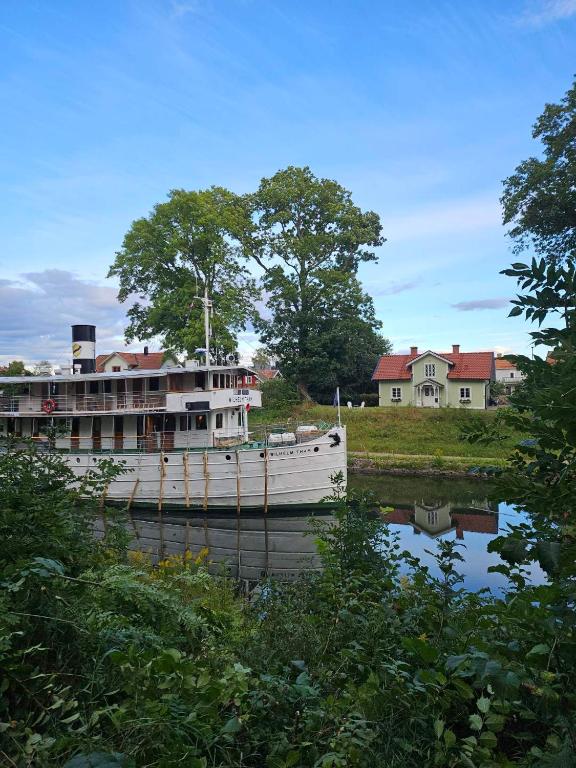 a boat on a river with houses in the background at Kanalhuset in Motala