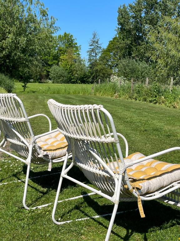 Zwei Stühle stehen im Gras in einem Garten. in der Unterkunft @TheLodge in Haarzuilens