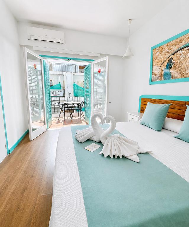 a bedroom with a large bed with a swan on it at Hostal Sunset Ibiza in San Antonio