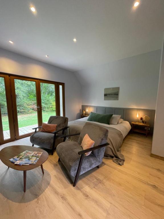 a bedroom with a bed and a table and chairs at Ecrin de Vizaille in Toucy