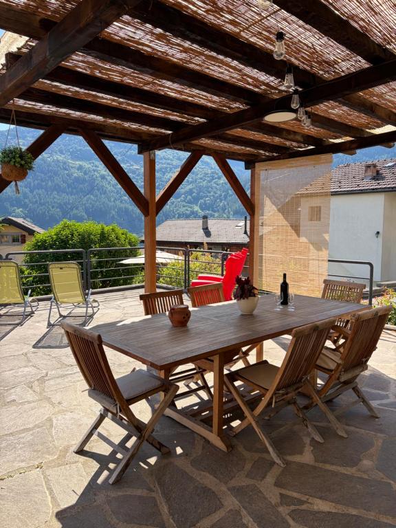 a wooden table and chairs on a patio at La Majorie de Nendaz in Nendaz