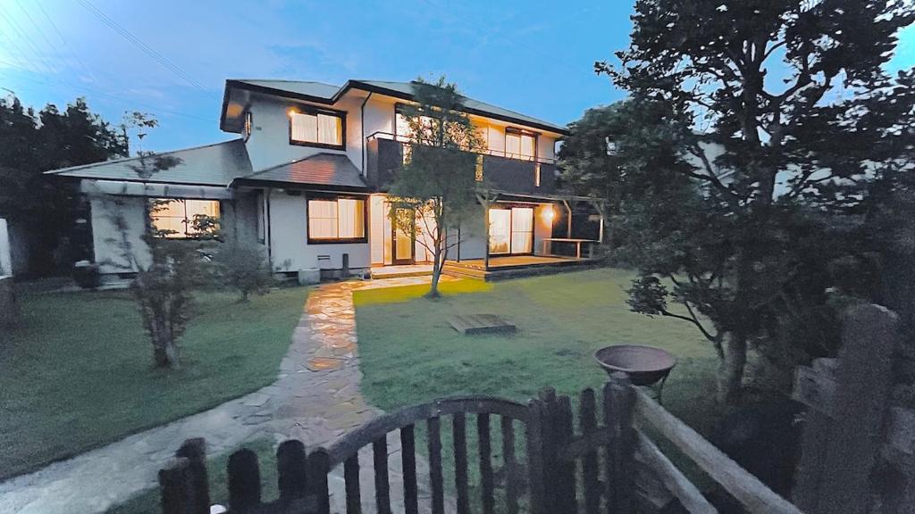 a large house with a fence in front of it at Sakai Garden and Villa in Sakai