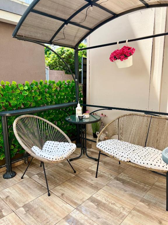 two chairs and a table under an umbrella on a patio at Summer Studio in Constanţa