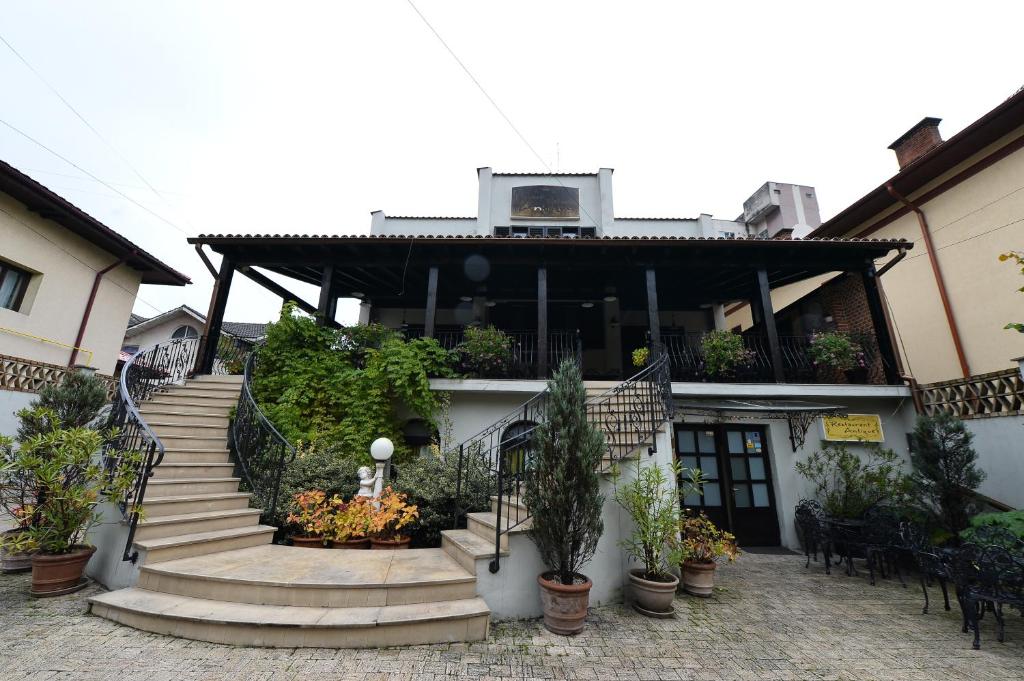 um edifício com escadas e vasos de plantas em frente em Pensiunea Antique em Târgu Jiu