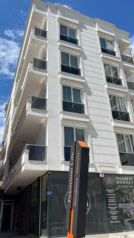 a tall white building with a sign in front of it at Premium Life Apart in Kapuluören