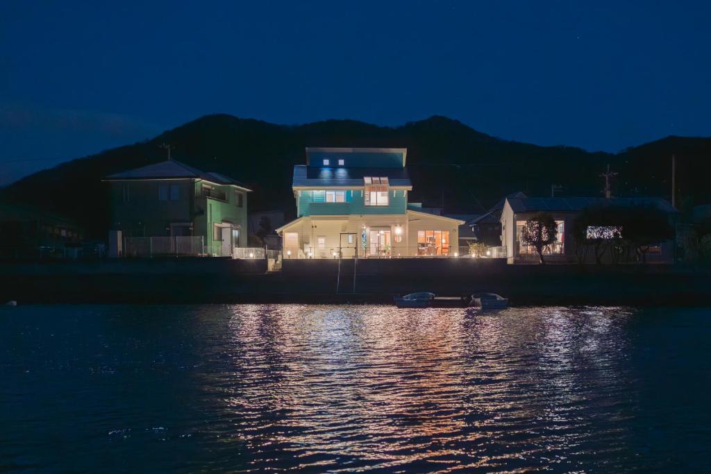 a house on the shore of a body of water at night at umiakari in Naruto