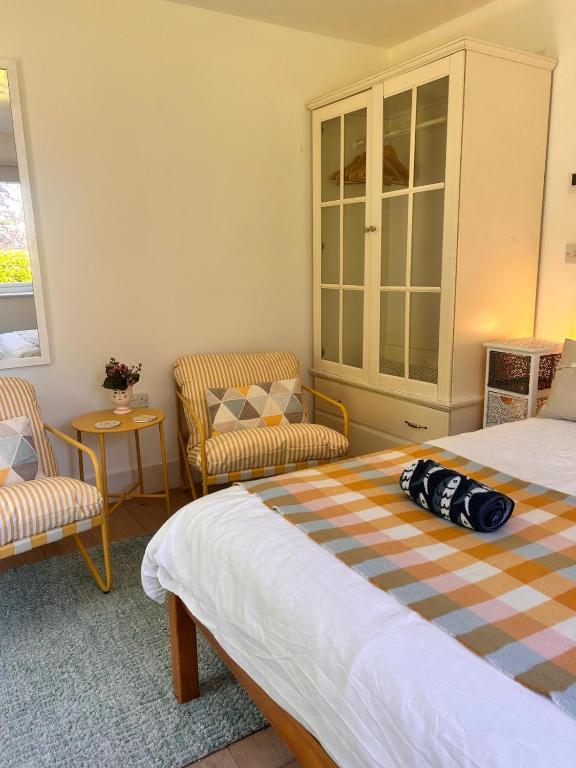 a bedroom with a bed and two chairs at The lighthouse in St Ives