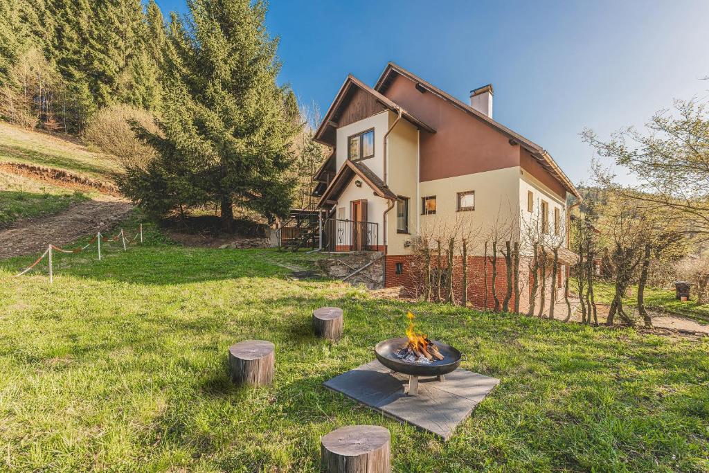 a house with a fire pit in the yard at Orličky Apartments in Orličky