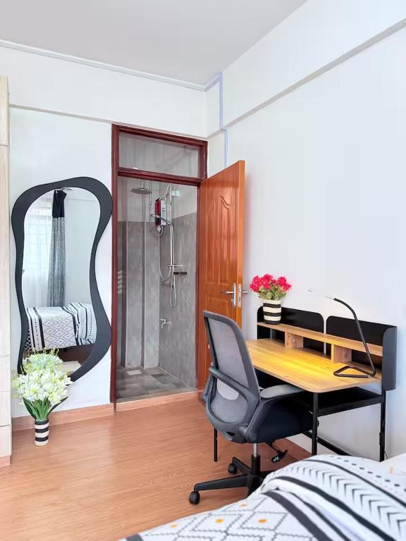 a bedroom with a desk and a shower and a chair at Unique west residence in Ruaka