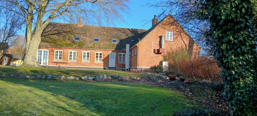 a large brick house with a tree in front of it at Gæstgiveri Bregninge in Ærøskøbing
