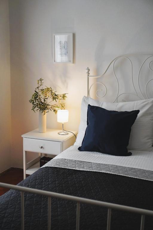 a bed with a black pillow and a table with a lamp at TT Apartmani - Historic Center Pula in Pula