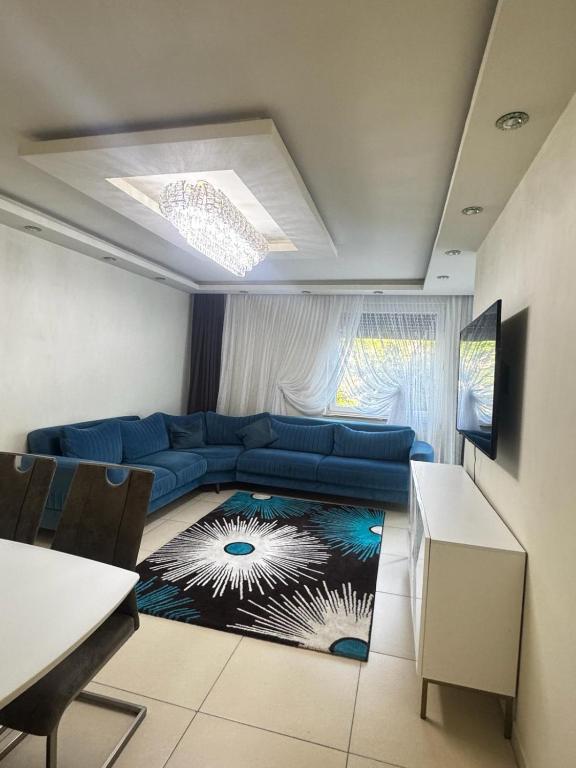 a living room with a blue couch and a table at Das gemütliche Unterkunft in Gelsenkirchen