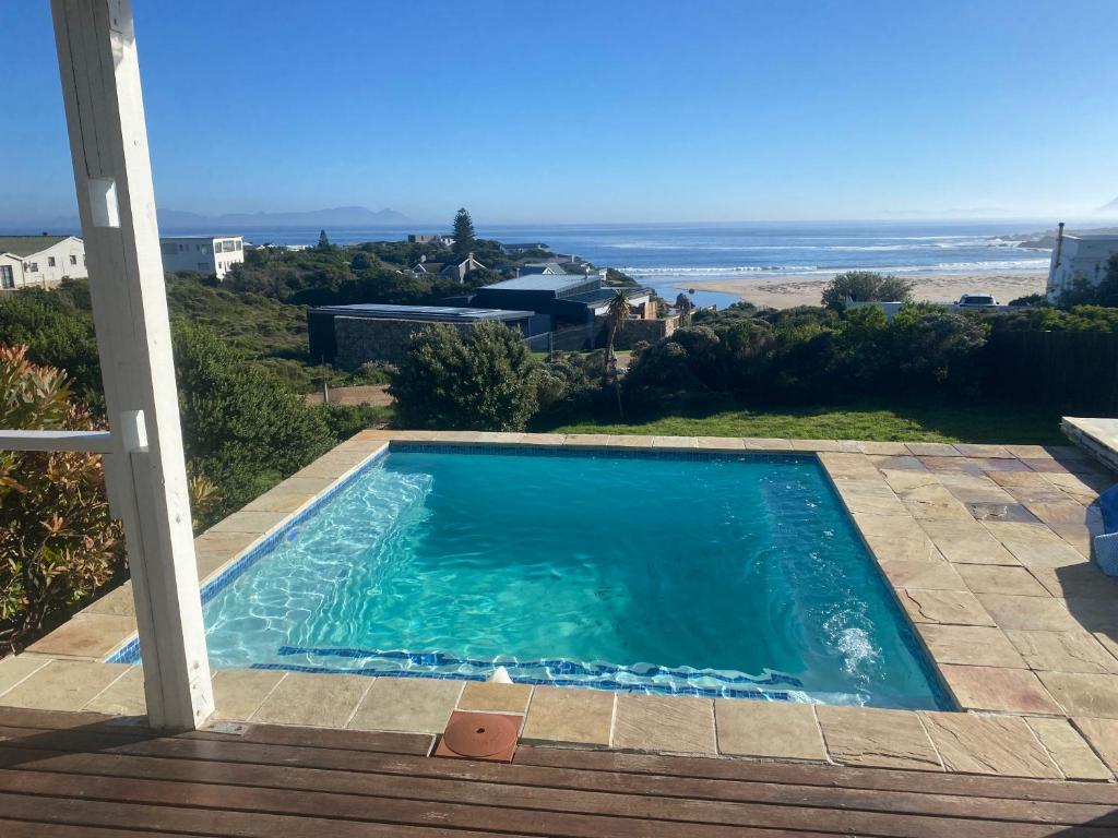 a swimming pool with a view of the ocean at Sea and Sky Rooiels in Rooiels