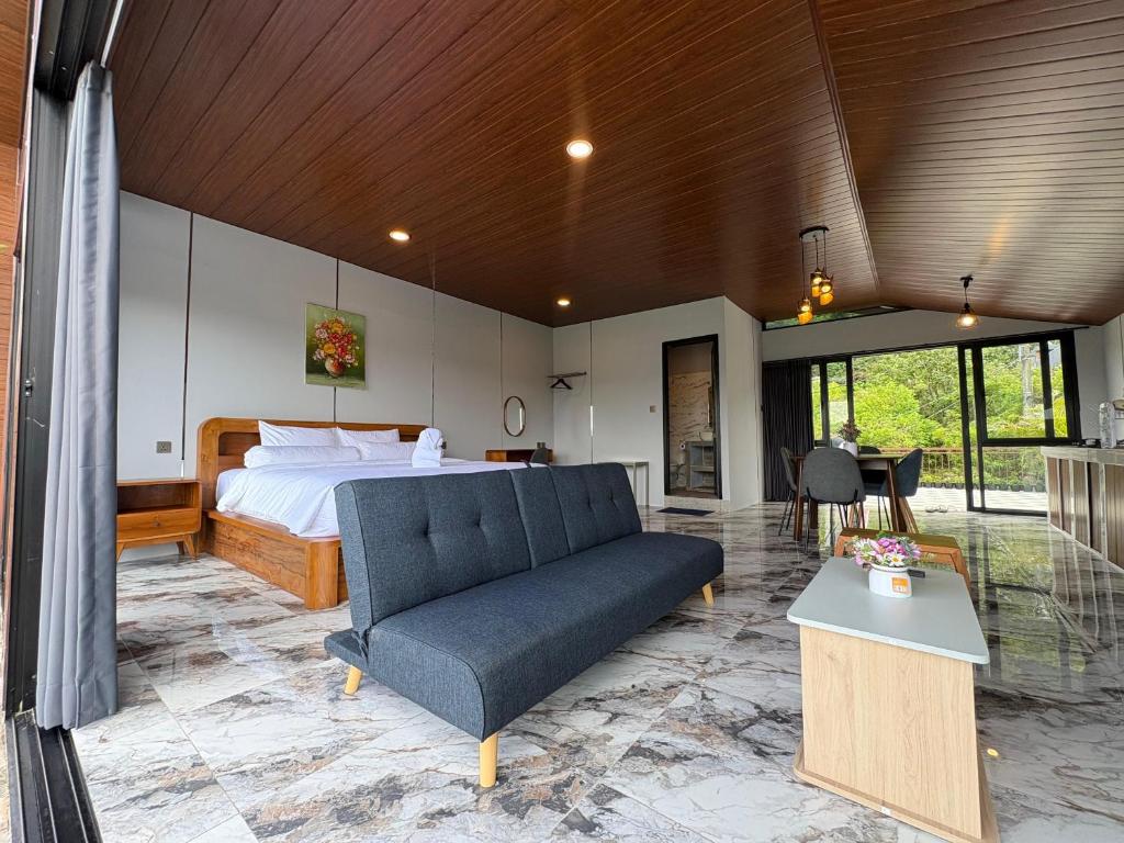 a bedroom with a bed and a couch in a room at Tera Bali Villa 3 Bedugul in Bedugul