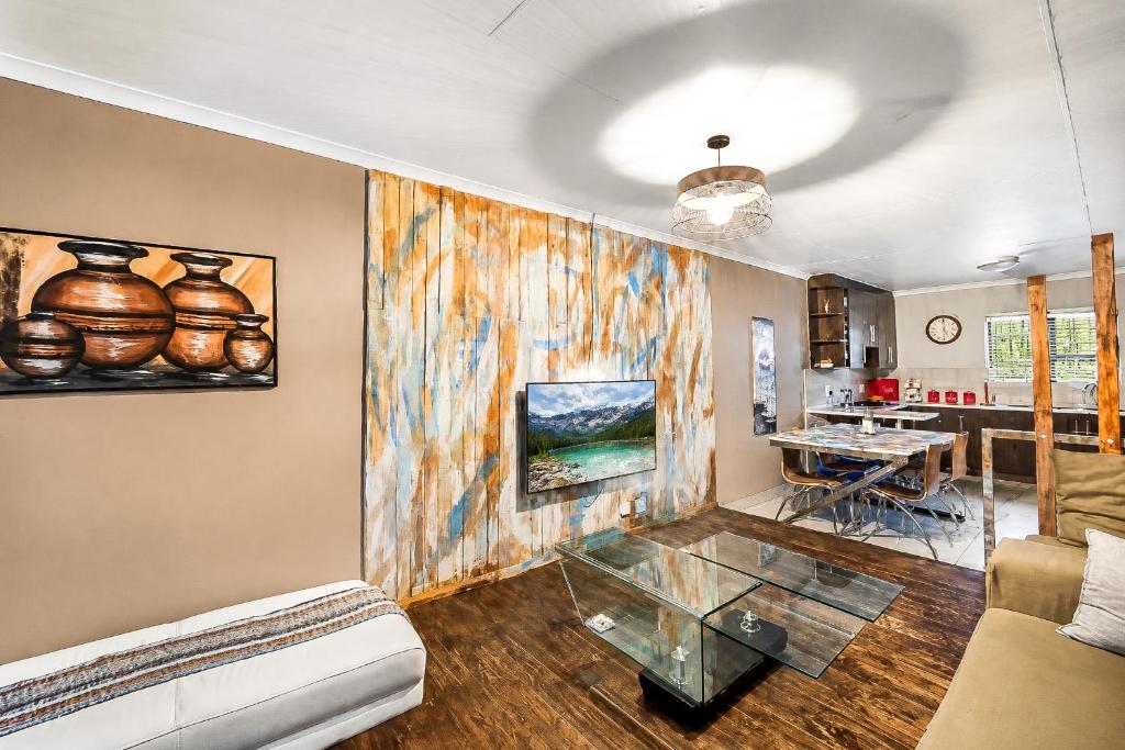 a living room with a couch and a glass table at Swallows Nest Haven in Boksburg