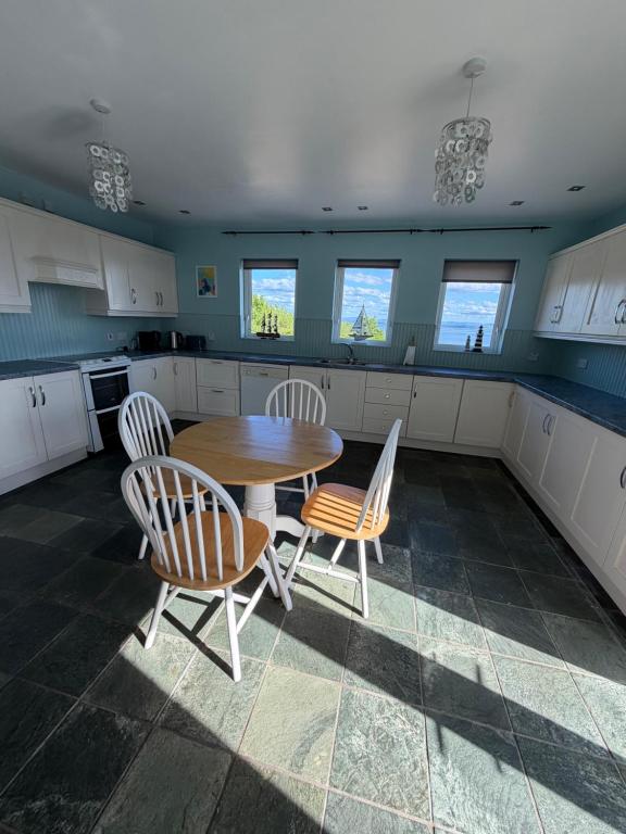 a kitchen with a wooden table and chairs at Tullyally House in Castle Cary