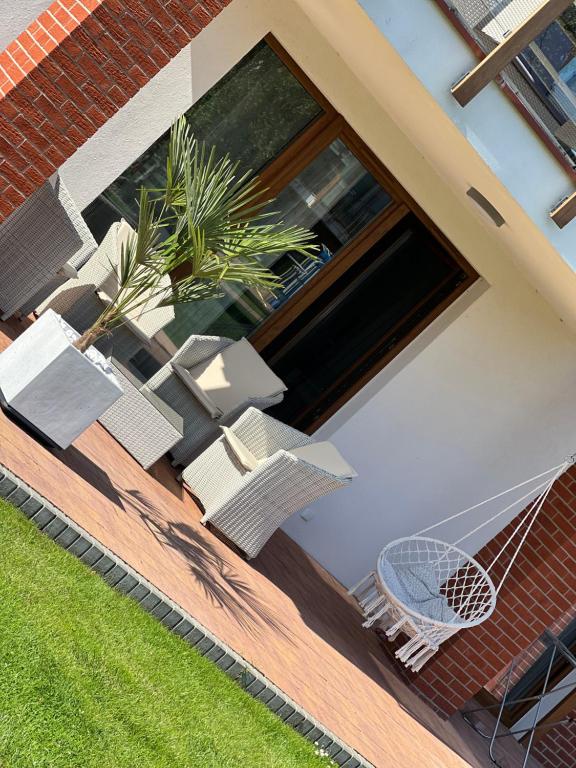 a house with a patio with chairs and a net at Łebska ostoja in Żarnowska