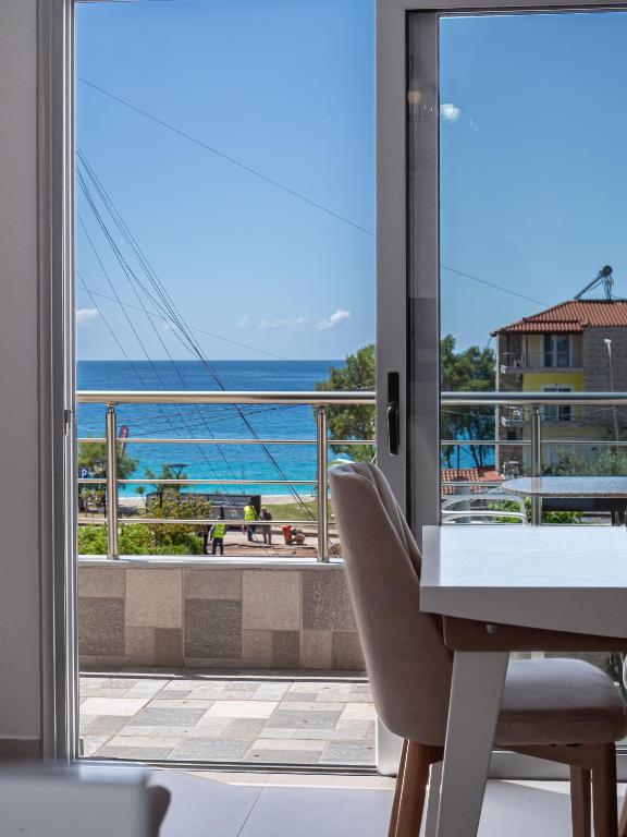 a room with a desk and a view of the ocean at Vourtaréa Guesthouse in Himare