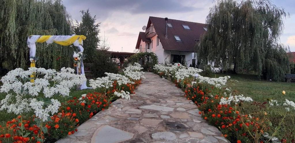a garden of white and red flowers in front of a house at Casa Salcia Oituz in Oituz