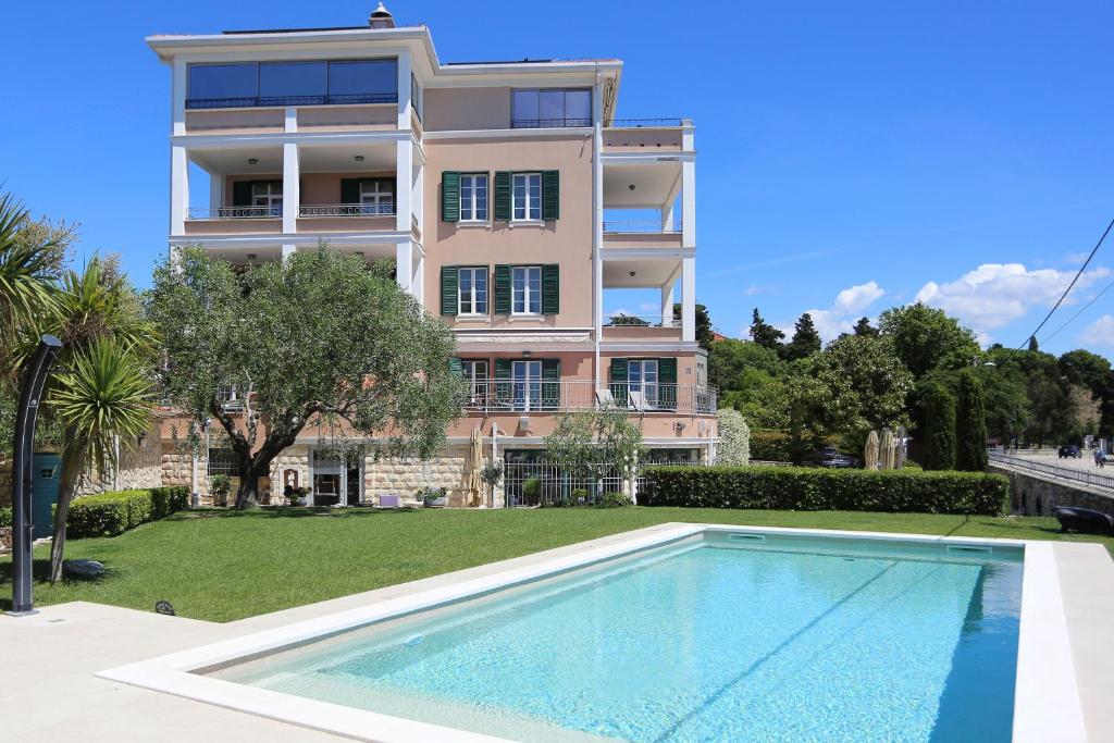 a building with a swimming pool in front of a building at Villa Hrešć I in Zadar