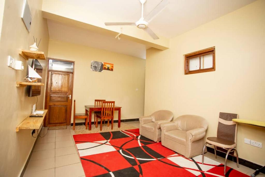 a living room with chairs and a dining room at Daf House in Zanzibar City