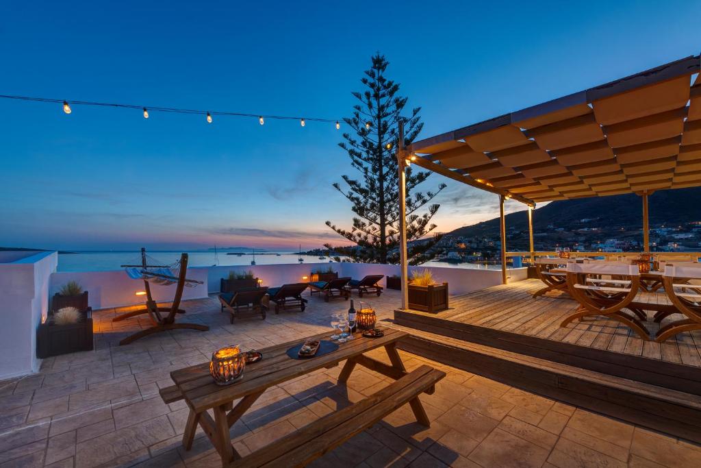 eine Holzterrasse mit einem Tisch und einigen Lichtern in der Unterkunft Brazzera Hotel in Finikas