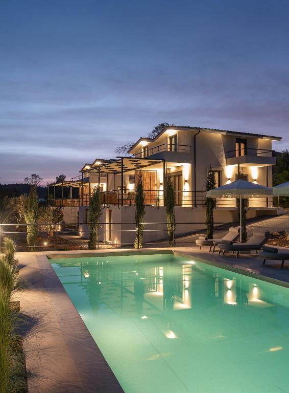 a house with a swimming pool in front of it at Enos Retreat Villas in Agios Nikolaos
