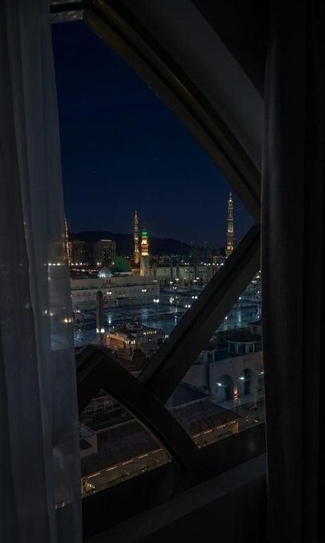 a view of a city at night from a window at Al Madina Golden Hotel in Medina