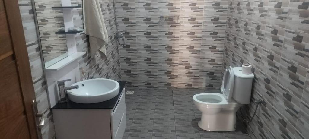 a bathroom with a toilet and a sink at Chez Roseline in Ndangane