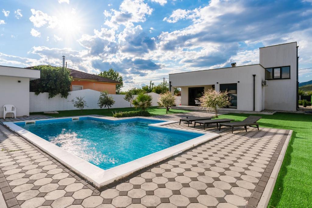 a swimming pool in the backyard of a house at Villa Elysian Blagaj in Blagaj
