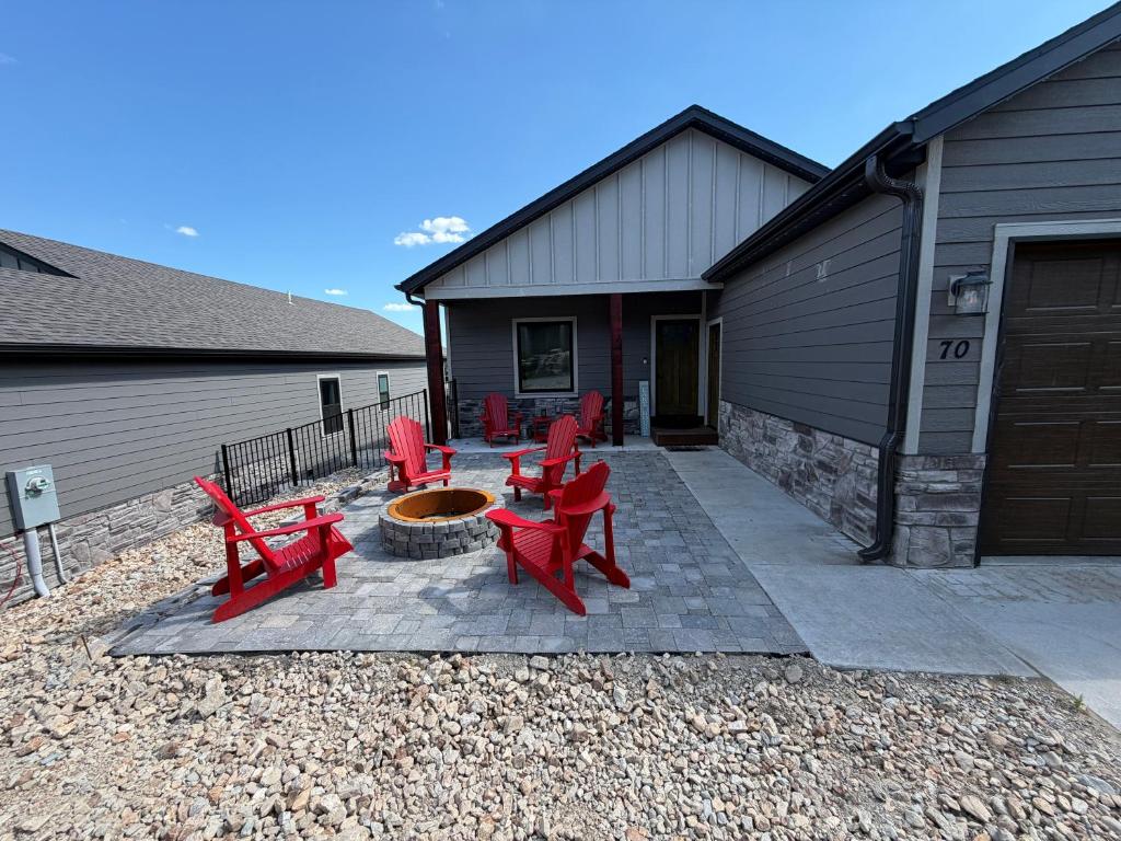 a patio with red chairs and a fire pit at Table Rock Lake Luxury Resort Lodge - Boat Slip in Branson