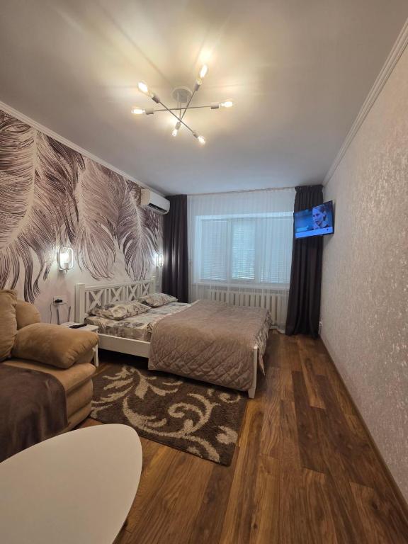 a bedroom with a bed and a couch at Апартаменты в центре in Chernihiv