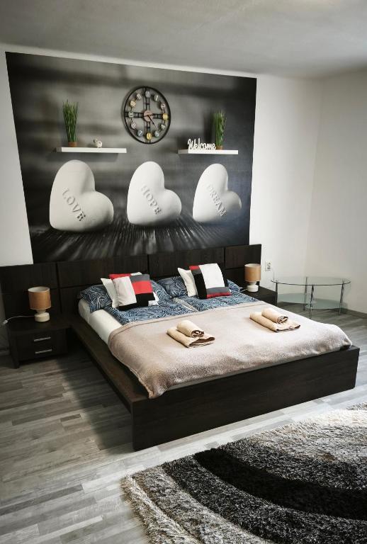 a bedroom with a bed with hearts on the wall at Freedom-Fehérvár apartman in Székesfehérvár