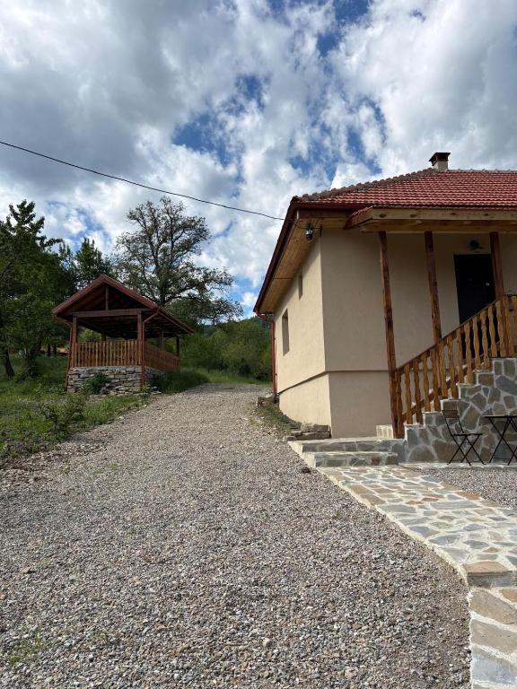 a house with a gravel road next to a building at Casa dintre munti in Bozioru