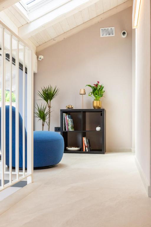 a living room with a blue ottoman and a book shelf at La Collina delle Rondini in Boves