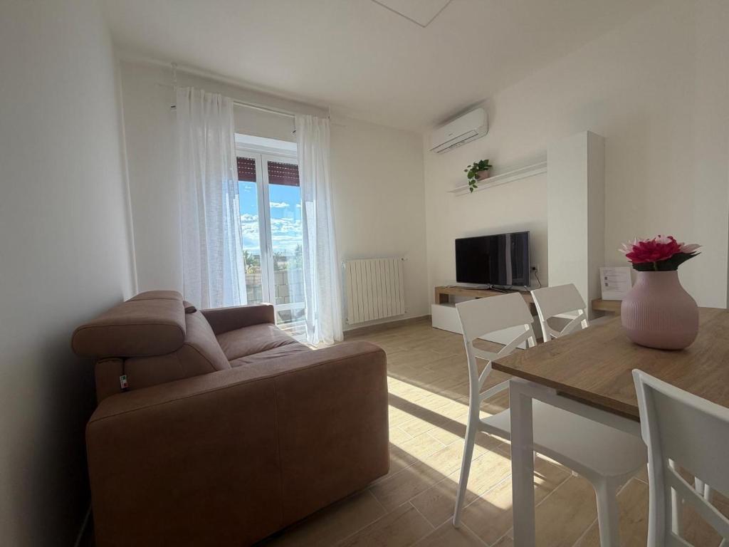 a living room and dining room with a couch and a table at Sky Balcony - Milano Sud- vicino Humanitas e forum Assago in Rozzano