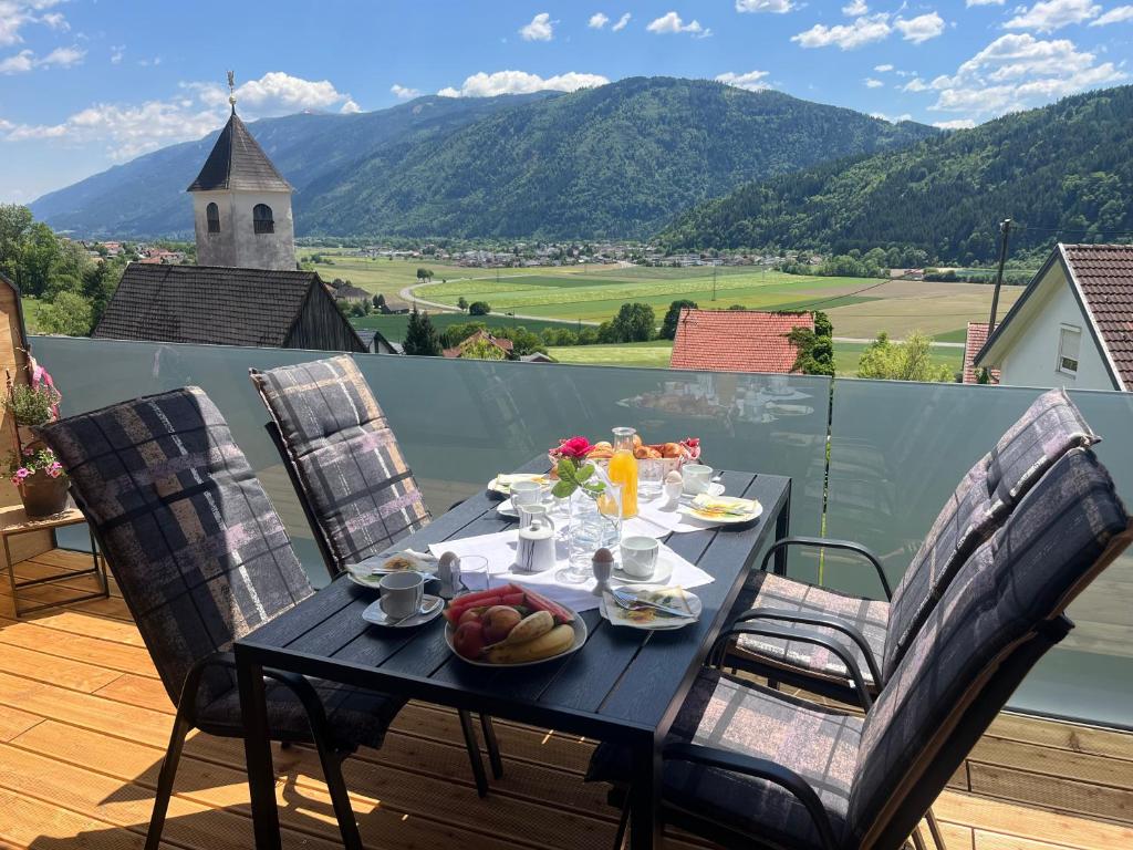 a table with food on top of a balcony with mountains at Appartement Dürnle Reißeck in Mühldorf