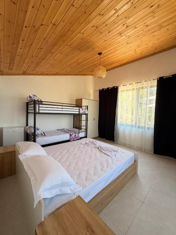 a large bed in a room with a wooden ceiling at Perseku GuestHouse in Shirokë